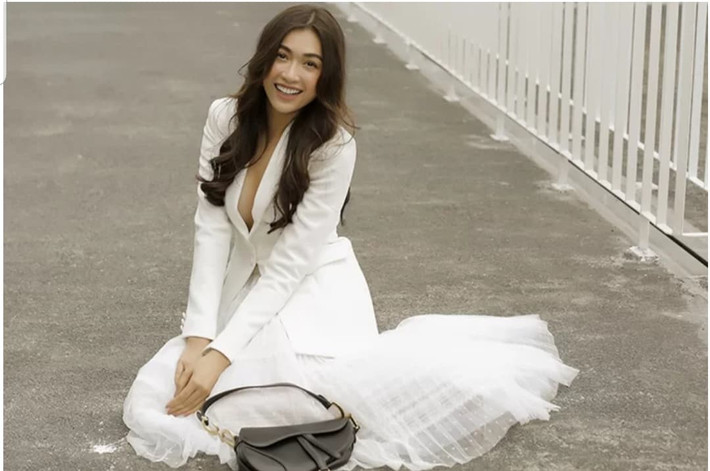Á hậu Lệ Hằng chọn vest trắng để phối cùng chân váy xoè. Style của cô giống với hoa hậu Mỹ Linh nhưng sexy hơn vì cổ xẻ sâu, để lộ cô không mặc bralette.