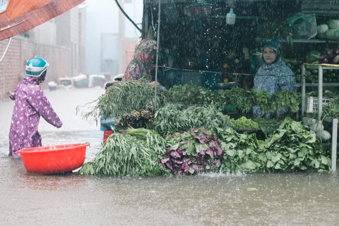 Dù mưa lớn, ngập sâu, các tiểu thương vẫn cố gắng duy trì việc buôn bán để cung cấp nhu yếu phẩm cho người dân đảo ngọc.