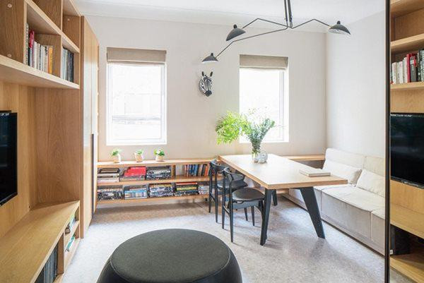 Không gian phòng khách với tủ, bàn, giá sách và ghế sofa.