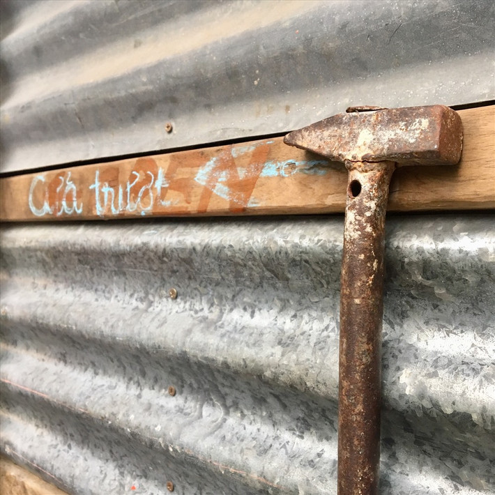 Những cánh cửa chỉ dùng các tấm tôn, gỗ cũ gắn những tay nắm là chiếc búa đã qua sử dụng.