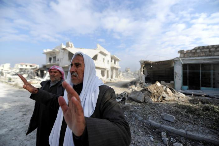Ông lão phản ứng khi đoàn phóng viên tới Sheikh Saeed, một quận ở thành phố Aleppo vào sáng 12/12. Ảnh Reuters