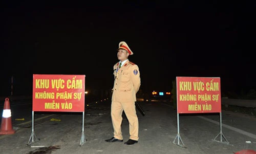 Ảnh: Cảnh sát cầm súng bảo vệ hiện trường nổ xe khách ở Bắc Ninh