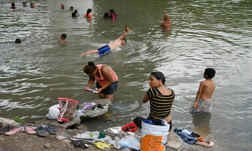 Cảnh dân nhập cư sống tạm bợ, tắm sông ở Mexico