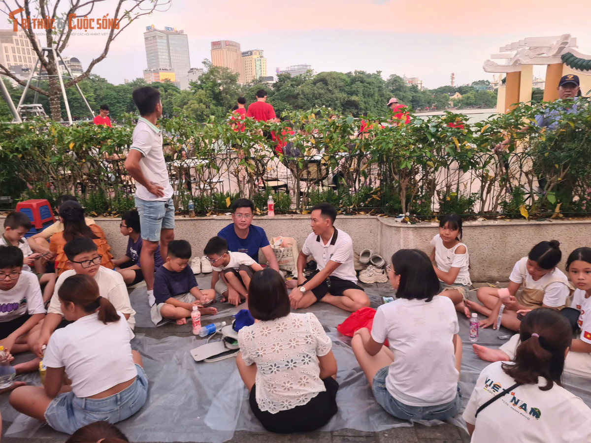 Người dân trải bạt ngồi chờ đến giờ bắn pháo hoa.