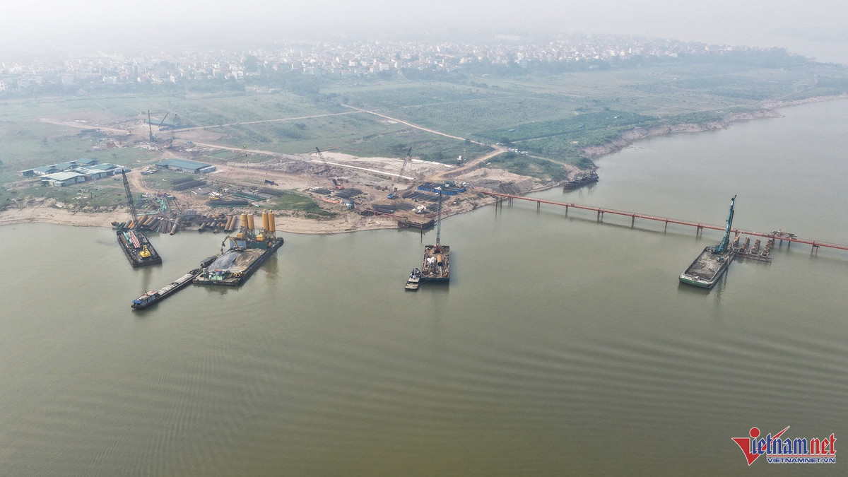 Cầu Hồng Hà với tổng mức đầu tư gần 10.000 tỷ đồng là công trình giao thông quan trọng bắc qua sông Hồng kết nối địa phận 2 xã Ô Diên - Mê Linh và là một trong ba cây cầu vượt sông thuộc dự án đường Vành đai 4 – Vùng Thủ đô. Bên cạnh đó, cầu còn giữ vai trò kết nối khu vực phía Tây và phía Bắc Hà Nội, tạo thành trục giao thông chiến lược xuyên sông Hồng. Công trường thi công cầu Hồng Hà nhộn nhịp với các máy công trình, cần cẩu cỡ lớn. Ảnh: Đức Hoàng