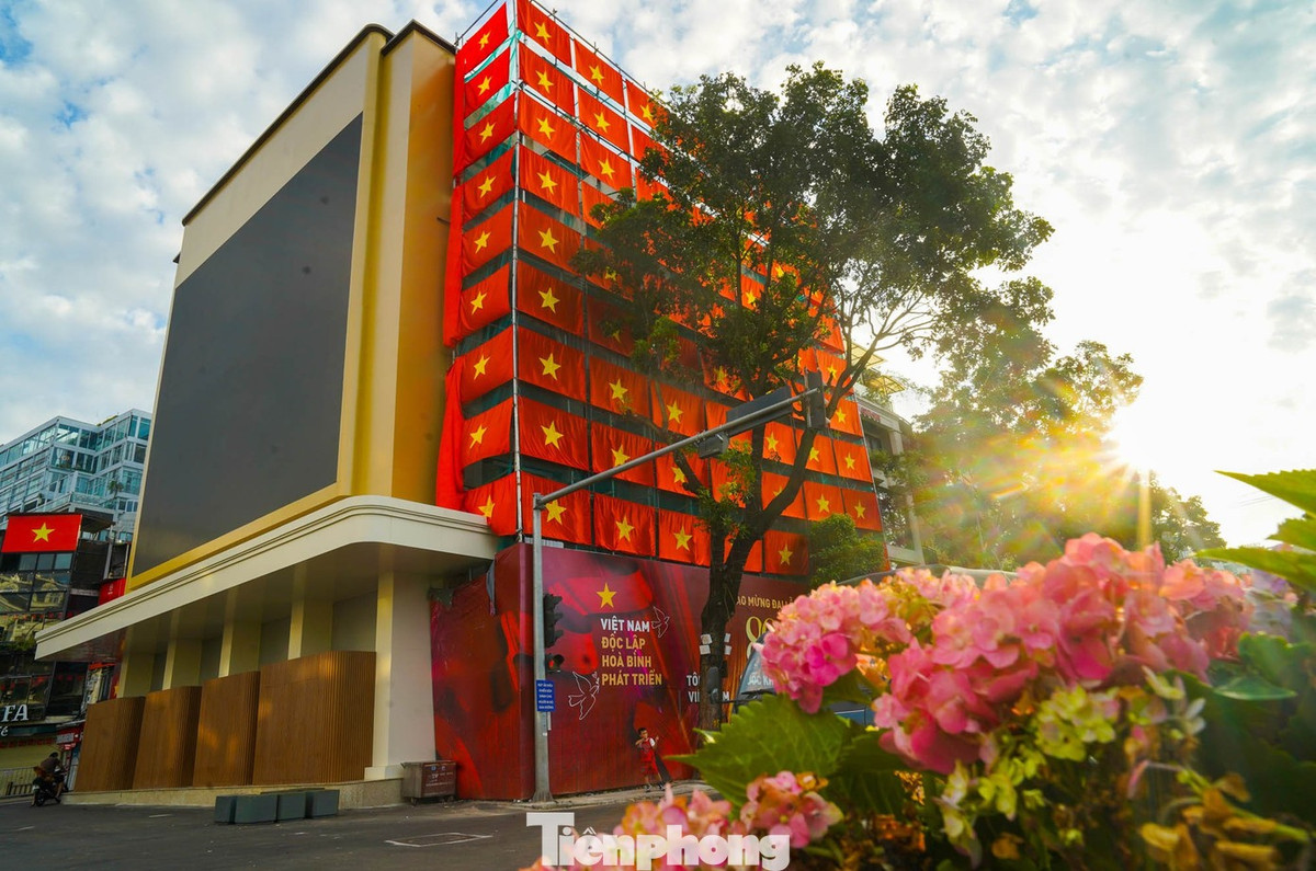 Phía mặt tòa nhà hướng ra Hồ Gươm hiện đang trong quá trình chỉnh trang lại mặt đứng và tầng tum, bên ngoài được trang trí bằng hàng trăm lá cờ Tổ quốc.