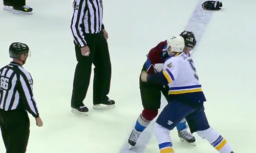 Hai cầu thủ đánh nhau, trọng tài đứng nhìn