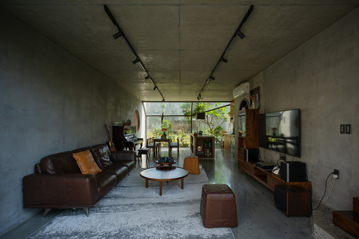 Phòng khách được bố trí gọn gàng, ngăn nắp với bộ ghế sofa màu nâu giúp nổi bật không gian. Chiếc pinano và đàn ghi ta là những dụng cụ âm nhạc để các thành viên có thể giải trí ngay tại nhà.