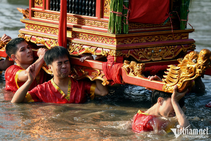 Khi mới đầm mình xuống nước, một số thanh niên khiêng kiệu tỏ ra nhăn nhó vì lạnh. Đây là những người tình nguyện được gánh vác công việc rất vất vả này. Họ phải đăng ký từ nhiều tháng trước và được bốc thăm theo kiểu "thánh lựa chọn".