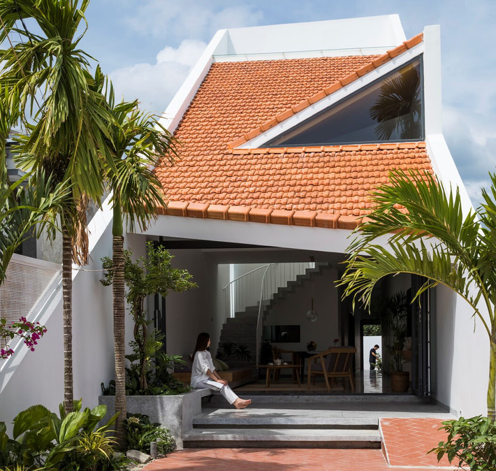 Mái ngói đỏ với độ dốc lớn giảm bớt sự vuông vức của ngôi nhà. Ngôi nhà đậm chất nông thôn thông qua sân trước và sân sau được lát bằng gạch nung, thể hiện rõ đặc trưng kiến trúc bản địa.