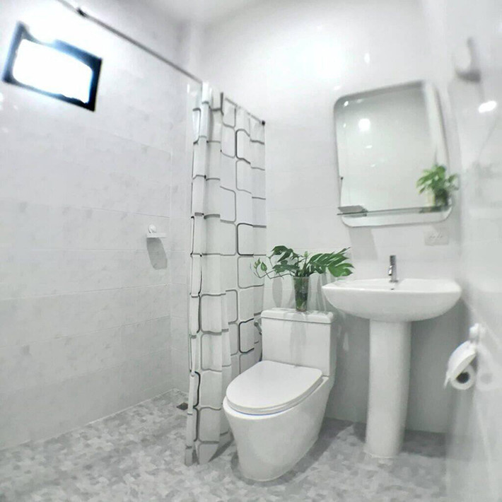 Nhà vệ sinh nhỏ được sơn màu trắng tạo cảm giác rộng rãi hơn.