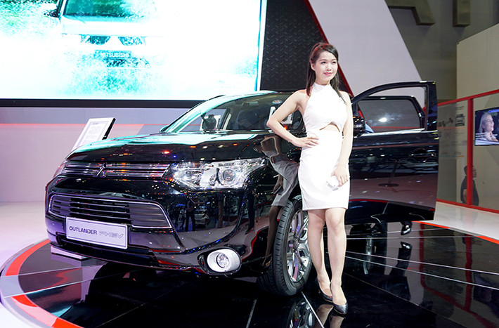 Gian hàng của Mitsubishi hấp dẫn người tham dự không chỉ bởi sự đa dạng về các mẫu xe trưng bày tại triển lãm mà còn bởi sự góp mặt của những người đẹp. Nổi bật nhất trong các mẫu xe Mitsubishi trưng bày tại đây là chiếc Outlander PHEV - mẫu xe SUV Hybrid của hãng.
