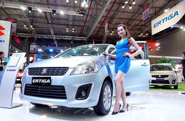 Người mẫu bên cạnh chiếc Ertiga của Suzuki.