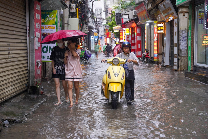 Một phương tiện giao thông bị chết máy, người điều khiển khó khăn di chuyển giữa trời mưa.