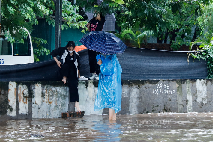 Một số đoạn, do vỉa hè cũng bị ngập sâu nên người đi bộ phải di chuyển trên bờ tường.