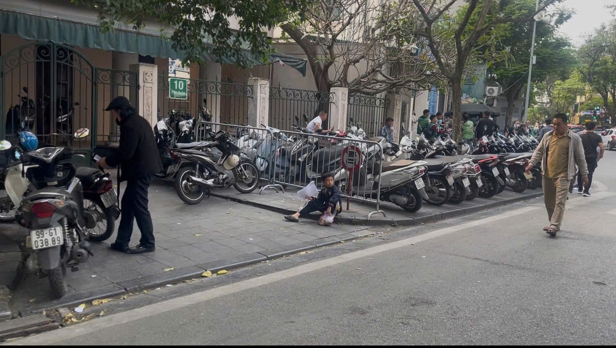 Vỉa hè bị chặn lại để tận dụng tối đa làm bãi gửi xe, người đi bộ buộc phải đi xuống lòng đường.