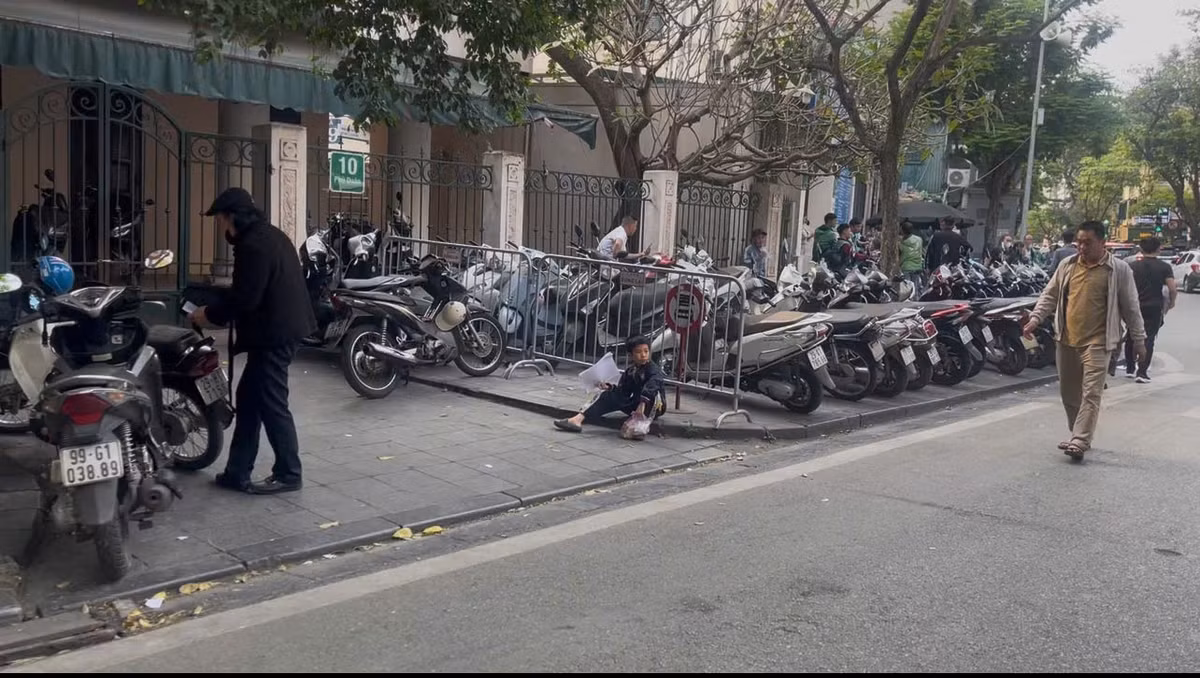 Vỉa hè bị chặn lại để tận dụng tối đa làm bãi gửi xe, người đi bộ buộc phải đi xuống lòng đường.