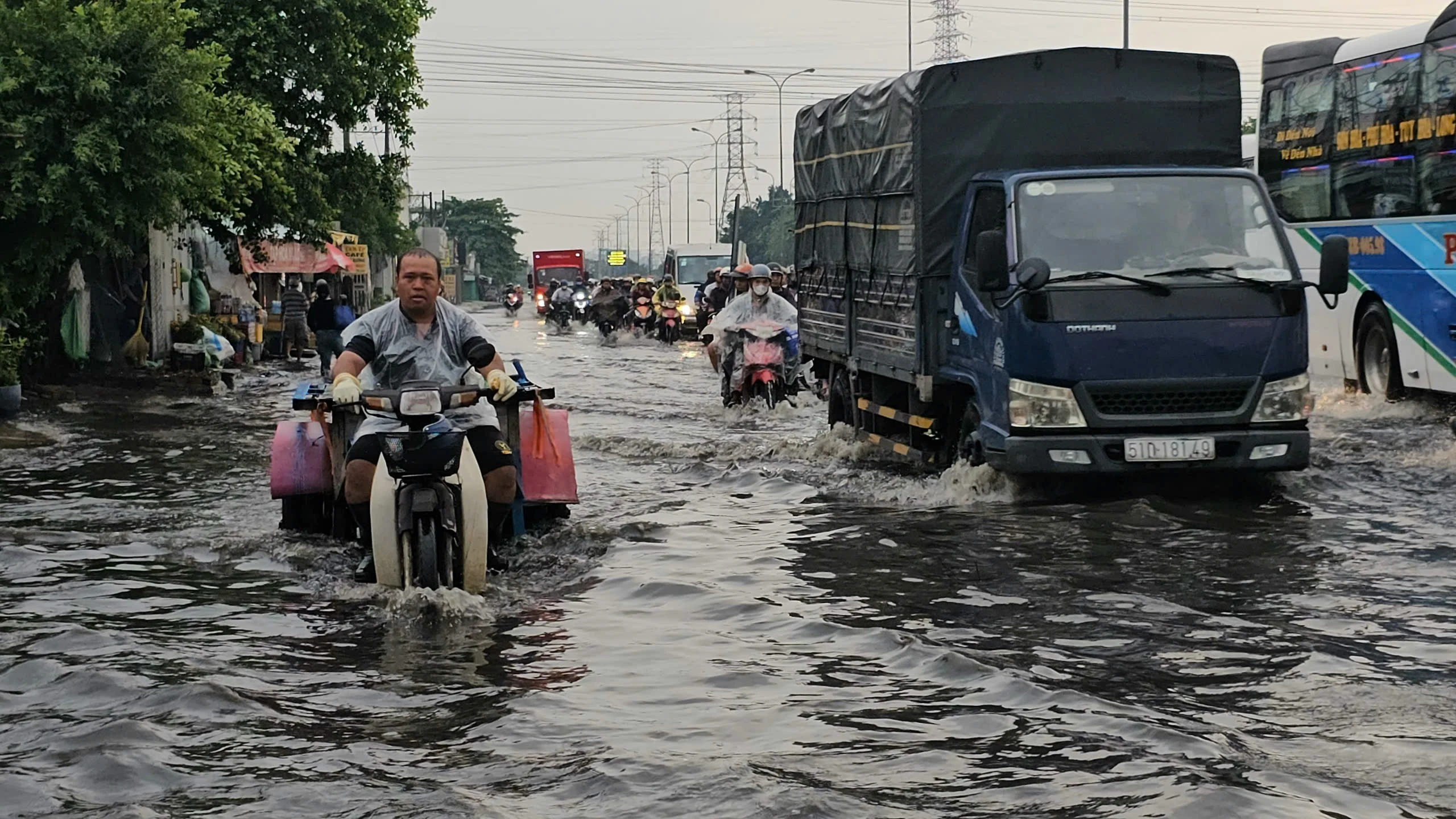 Mưa trái mùa, người dân TP HCM bì bõm trong nước ngập
