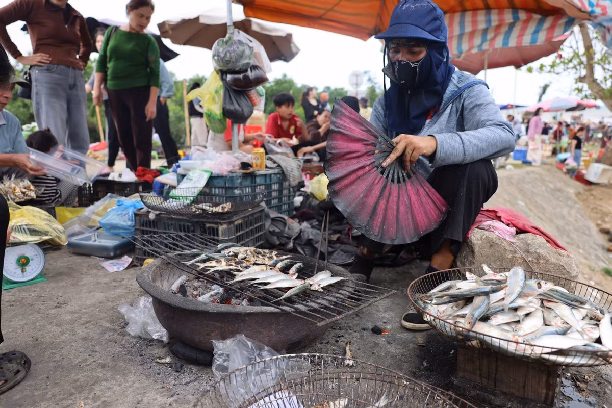 Những quầy nướng giản dị được dựng tạm ven bờ nhanh chóng kín chỗ. Người dân liên tục tay lật cá, tay phục vụ khách, gần như không có thời gian nghỉ. Có thời điểm, khách phải chờ vì lượng cá nướng không kịp đáp ứng. Ảnh Việt Phong