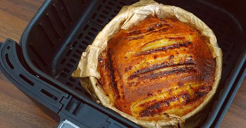 Bánh được nướng trong nồi chiên không dầu ở 160 độ C trong 15 – 20 phút. Khi bánh chín, thử chọc que tăm vào giữa bánh; nếu que tăm không dính bột ướt nghĩa là bánh đã sẵn sàng. Thành phẩm có mặt ngoài xém giòn, bên trong mềm xốp, ẩm mượt, hương vị chuối, cacao và quế hài hòa, hấp dẫn ngay từ miếng cắn đầu tiên. Ảnh minh họa