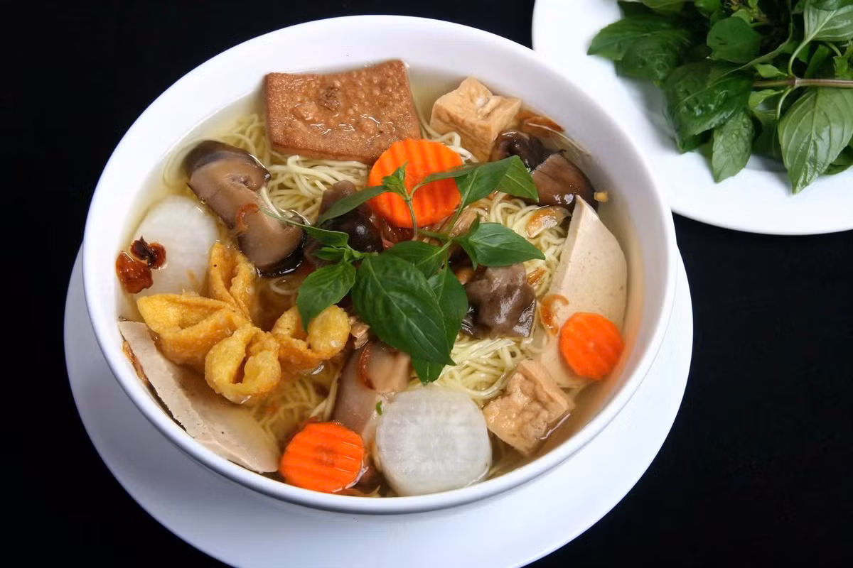 Món ăn được nấu hoàn toàn từ rau củ quả, nước dùng ngọt thanh, sợi hủ tiếu dẻo dai ăn kèm nấm, chả chay, đậu hũ và rau ngò. Không cần thịt cá, chỉ với vị thanh mát tự nhiên ấy, hủ tiếu chay vẫn đủ sức chinh phục cả những thực khách khó tính. Ảnh amthuc