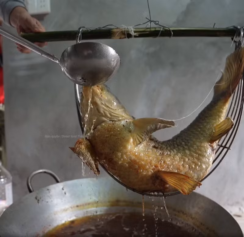 Theo người làng Diệc, một con cá “nằm võng” đạt chuẩn phải hội tụ đủ các yếu tố: thân cong như mái đình, miệng mở to, mắt cá còn nguyên, vảy đều và óng ánh. Nếu không đủ tiêu chí, cá phải chế biến lại từ đầu, thể hiện sự cầu kỳ và tôn trọng truyền thống. Ảnh FB Street Food