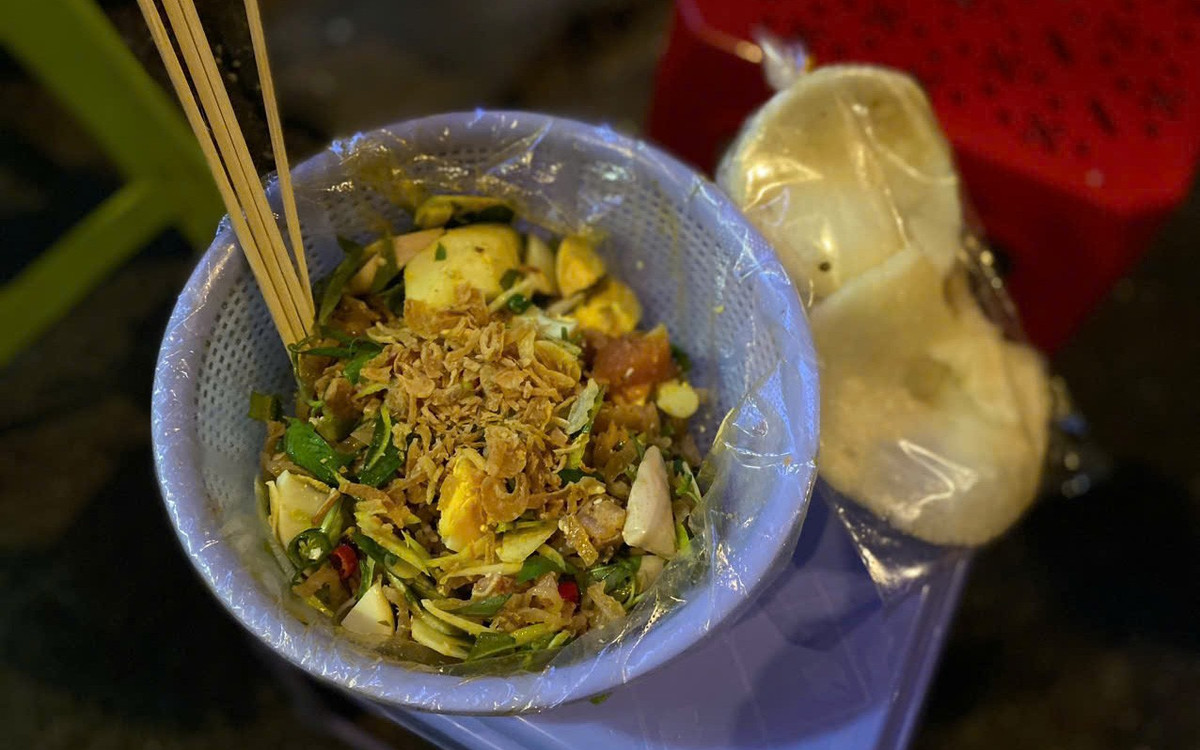 Ngay khu vực ga tàu lửa Sài Gòn, đoạn 1 Nguyễn Thông (phường Xuân Hòa), không khí về đêm lúc nào cũng rộn ràng. Những gánh tré trộn, bánh tráng trộn nối nhau sáng đèn từ chiều tối đến tận rạng sáng hôm sau, trở thành điểm hẹn quen thuộc của người trẻ. Một phần tré trộn đầy đặn, ăn kèm bánh phồng giòn tan, vị chua chua, cay cay hòa cùng mùi rau thơm rất “bắt miệng”. Bánh tráng trộn giá mềm, dễ mua mang về, càng khiến khu phố nhỏ này thêm tấp nập mỗi khi đêm về. Ảnh Thái Bảo