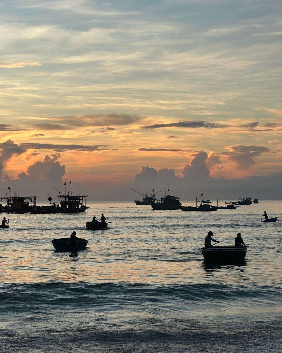 Ánh sáng buổi sớm chiếu xiên qua làn sương, phủ lên những rổ hải sản ánh vàng nhẹ. Sóng vỗ rì rào, bàn tay người vội vã nhưng khéo léo, tiếng mặc cả rộn ràng tạo nên một bản hòa âm rất riêng – một nhịp sống biển giản dị, chân phương mà lay động lòng người. Ảnh Thanh Tuan