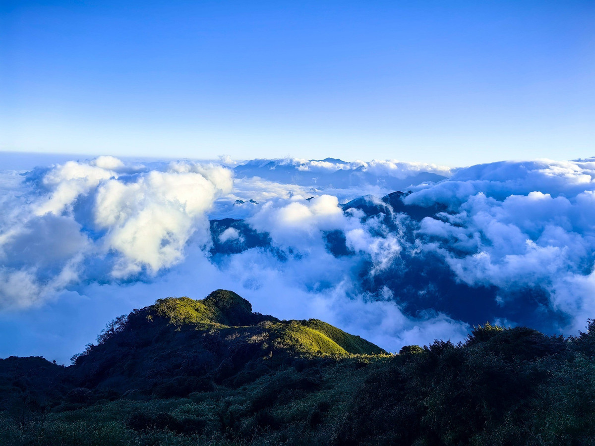 Mỗi mùa, Nhìu Cồ San lại khoác lên mình vẻ đẹp khác biệt. Cuối thu – đầu đông (khoảng tháng 11–12), rừng phong chuyển sắc vàng đỏ, hòa cùng thảm rêu xanh rì tạo nên bức tranh màu sắc quyến rũ. Với nhiệt độ xuống thấp vào tháng 1, băng tuyết có thể xuất hiện trên đỉnh, mang lại trải nghiệm hiếm hoi giữa vùng núi cao. Ảnh Van Ngo
