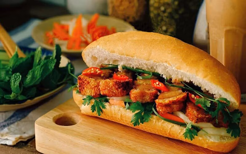 Bánh mì heo quay là sự kết hợp hài hòa giữa vỏ bánh mì giòn truyền thống và thịt ba chỉ heo quay da giòn – nguyên liệu vốn được yêu thích trong nhiều nền ẩm thực. Đây được xem là biến tấu đặc sắc của bánh mì Việt Nam, mang đến trải nghiệm mới mẻ so với các loại nhân quen thuộc. Ảnh minh họa