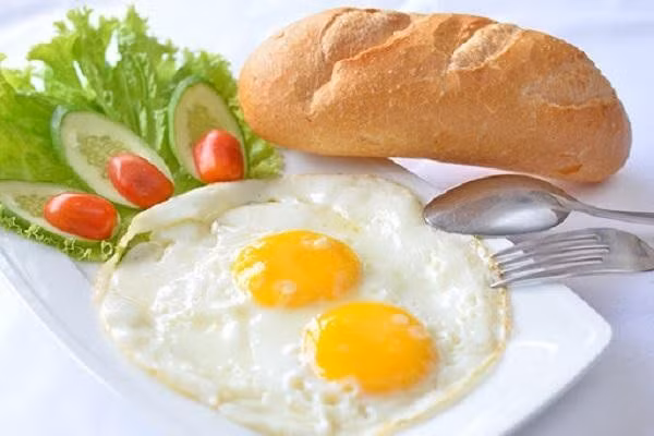 Nếu yêu thích sự nhanh gọn, trứng ốp la ăn kèm bánh mì và xà lách là lựa chọn vừa ngon vừa giàu năng lượng. Ảnh minh hoạ