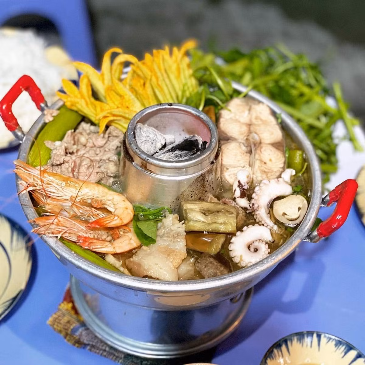 Chiếc nồi lẩu cù lao không chỉ là món ăn mà còn là trải nghiệm văn hóa. Hương than cháy, mùi nước dùng ngọt thanh và hình ảnh nồi lẩu đầy ắp nguyên liệu gợi nhắc cuộc sống dân dã, tình người miền Tây. Ảnh TapchidulichTPHCM