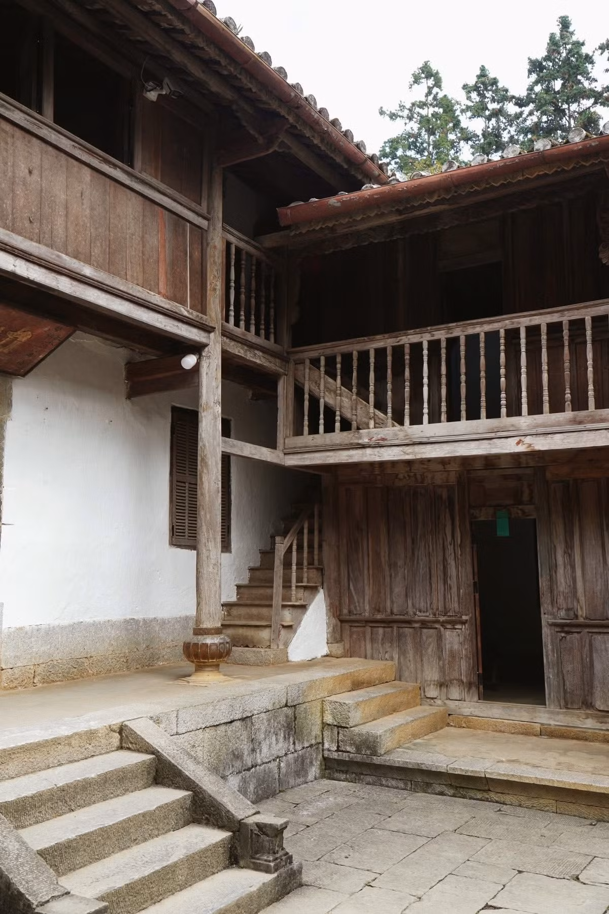 Điều đặc biệt thu hút du khách là kiến trúc pha trộn tinh tế giữa phong cách Pháp, Trung Hoa cổ và bản sắc H’Mông. Những hành lang gỗ thông được nâng đỡ bằng cột gỗ nghiến chắc chắn, mái ngói âm dương cong vút mềm mại, các mảng đá xanh chạm khắc cầu kỳ… tất cả đều tạo nên một không gian vừa cổ kính vừa sang trọng. Ảnh Tăng Kim Ngân