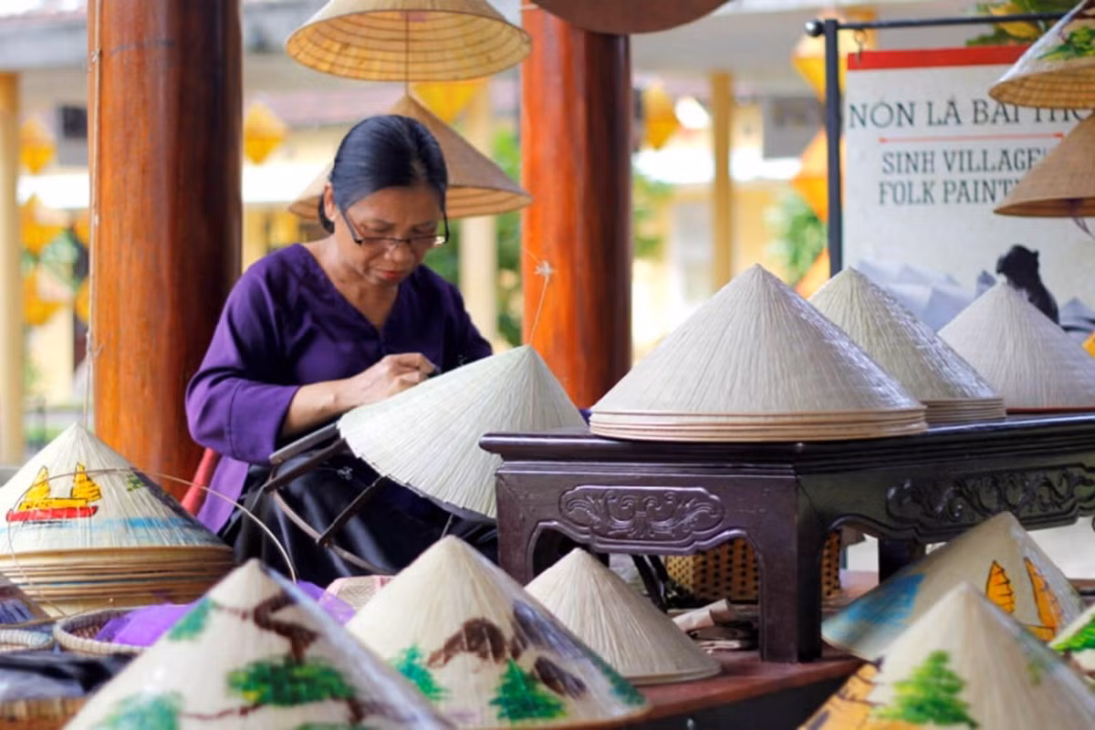 Nhắc đến Huế là nhắc đến chiếc nón bài thơ – biểu tượng của nét duyên thầm và sự tinh tế. Làng Tây Hồ chính là cái nôi gìn giữ kỹ nghệ làm nón độc đáo này. Điểm đặc biệt của nón bài thơ nằm ở những câu thơ, hình ảnh danh thắng xứ Huế được khéo léo lồng ghép giữa hai lớp lá, chỉ hiện lên khi soi dưới ánh sáng. Ảnh Sovabatravel