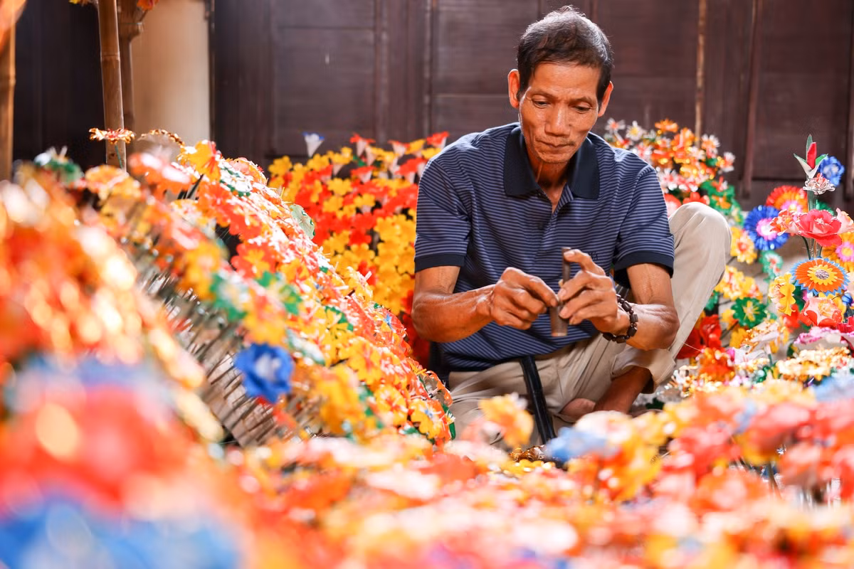 Nằm yên bình bên dòng sông Hương, làng Thanh Tiên đã gìn giữ nghề làm hoa giấy suốt hơn 300 năm. Khác với hoa thật, hoa giấy Thanh Tiên mang vẻ đẹp bền bỉ, mộc mạc, được tạo nên từ giấy dó và màu nhuộm thiên nhiên. Ảnh Giang Ngọc