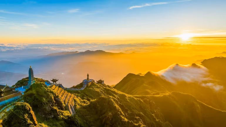 Fansipan đẹp nhất vào hai thời khắc đối lập: bình minh và hoàng hôn. Khi mặt trời nhô lên, biển mây chuyển màu vàng rực, lấp lánh như sóng ánh sáng đang nhảy múa giữa bầu trời. Ảnh Hoàng Trung Hiếu