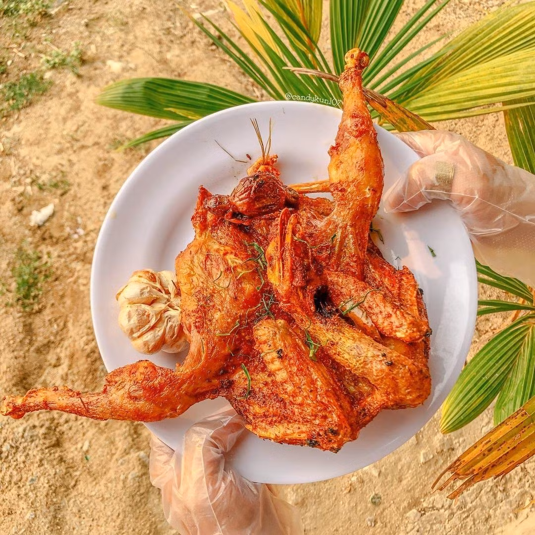 Khi dọn lên bàn, gà đốt lá chúc gây ấn tượng mạnh với lớp da vàng như mật ong, hơi giòn, trong khi thịt bên trong mềm, mọng và tỏa mùi thơm dìu dịu của lá chúc. Ảnh @candykun107