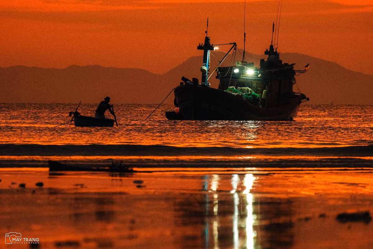 Khi bình minh hé rạng, từ trên cao nhìn xuống, làng chài hiện lên như một bức tranh sống động hòa quyện giữa sắc xanh của biển cả, màu sắc rực rỡ của những chiếc thuyền đánh cá và nhịp sống sớm mai tất bật của cư dân nơi đây. Ảnh Mây Trắng
