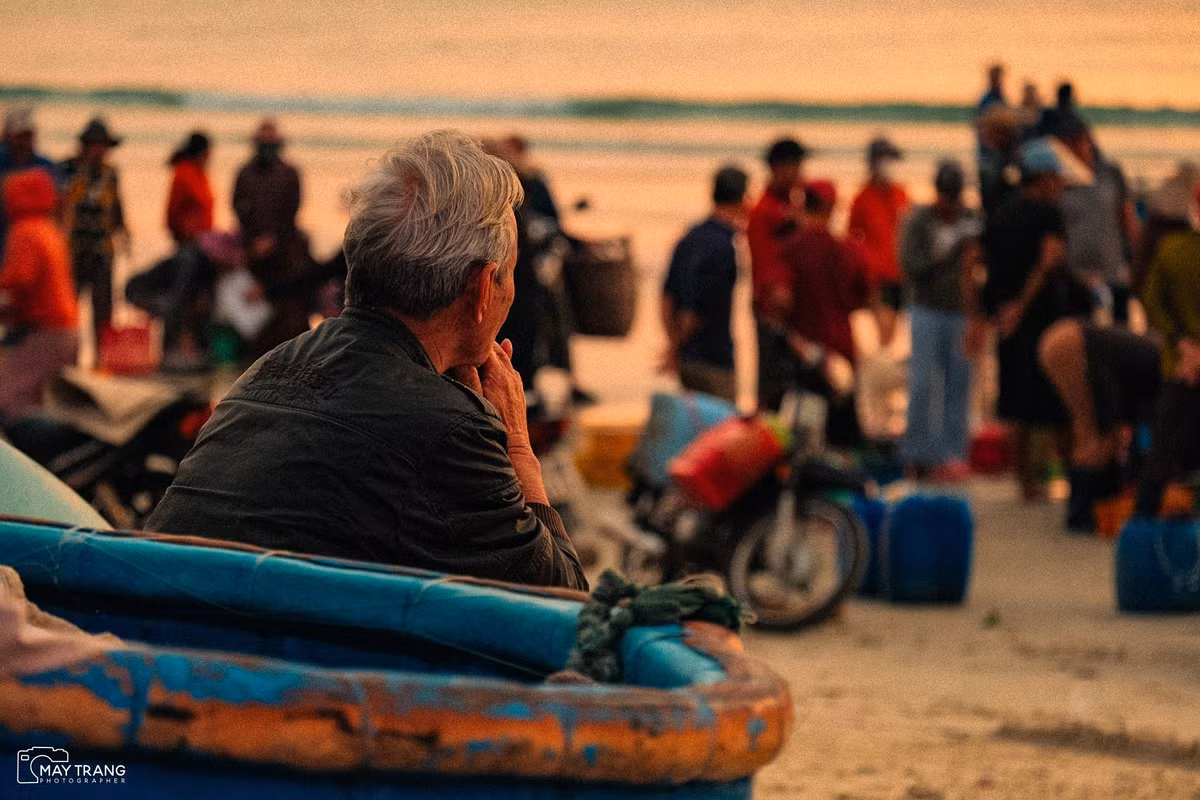 Ánh sáng dịu dàng của ngày mới làm nổi bật từng mái nhà, từng dãy lưới cá và gương mặt người dân tràn đầy sức sống. Ảnh Mây Trắng