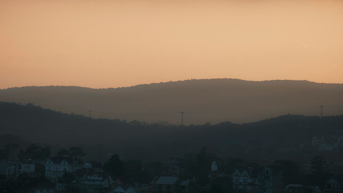 Khoảng 17h đến 18h, thành phố trên cao nguyên bắt đầu khoác lên mình lớp áo chiều dịu dàng. Ánh nắng không còn gay gắt mà chuyển sang vàng nhạt, rồi dần dần chuyển tím. Những lớp mây mỏng bay là đà ngang lưng núi, hòa quyện với sương giăng bảng lảng, khiến khung cảnh như bức tranh thủy mặc. Ảnh Thành Đạt Phan