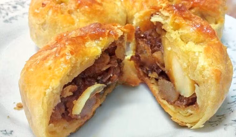 Cắn một miếng, bạn sẽ cảm nhận được lớp vỏ giòn tan hòa quyện với vị ngọt bùi của thịt xá xíu, sự béo ngậy của trứng và vị thơm của hành phi, tạo nên một món ăn vừa đơn giản, vừa đầy đặn hương vị. Ảnh MIA