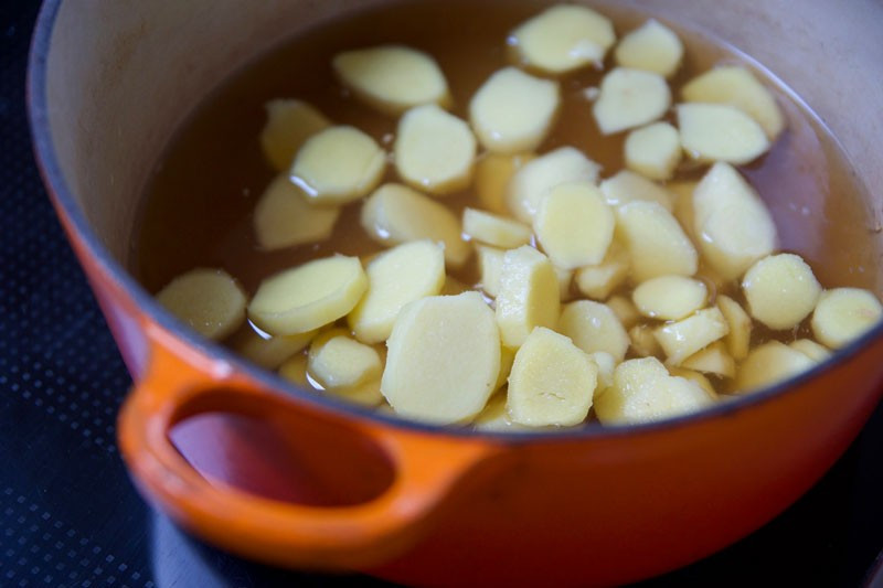 Gừng sau khi rửa sạch, cạo vỏ được thái lát mỏng rồi ngâm ngay vào nước muối loãng để tránh thâm và giảm mùi hăng. Sau đó, gừng được rửa lại vài lần với nước sạch rồi đem chần nhanh trong nước sôi có vắt thêm chút cốt chanh. Công đoạn chần giúp gừng dịu bớt vị cay gắt nhưng vẫn giữ trọn mùi thơm. Ảnh minh họa/Nguồn internet