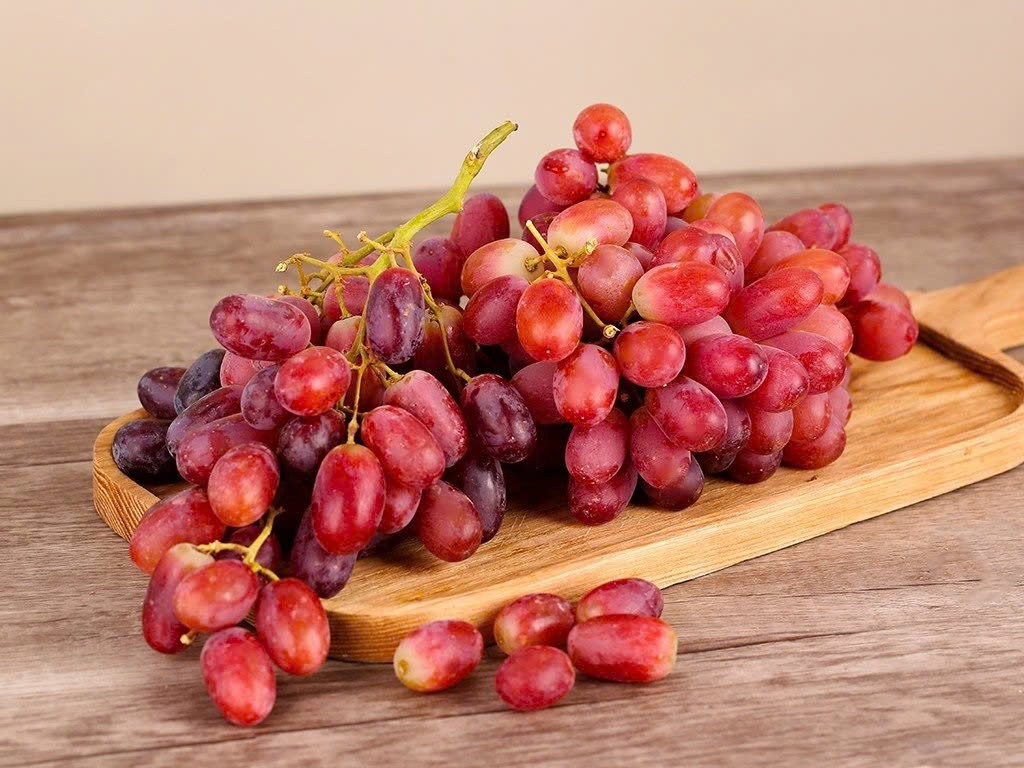 Không thể không nhắc đến nho đỏ – loại quả chứa resveratrol trong vỏ và hạt, được ví như “lá chắn chống lão hóa” tự nhiên. Resveratrol giúp bảo vệ tế bào da khỏi tác hại của tia UV và môi trường, đồng thời ổn định cấu trúc collagen, làm giảm nếp nhăn và cải thiện độ đàn hồi. Thường xuyên ăn nho hoặc uống nước ép nho đỏ giúp da hồng hào, khỏe mạnh từ bên trong. Ảnh minh họa