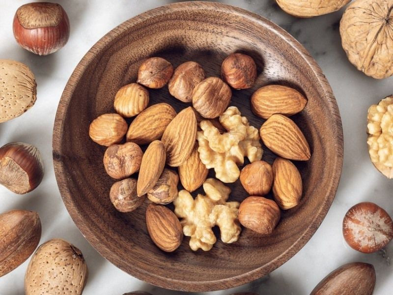 Hạnh nhân, óc chó, hạt điều… cung cấp axit béo không bão hòa và chất xơ, hỗ trợ giảm cholesterol xấu LDL. Mỗi ngày, ăn khoảng 50–60 gram quả hạch là vừa đủ. Có thể dùng trực tiếp hoặc trộn cùng salad, ngũ cốc để tăng hiệu quả. Ảnh minh họa