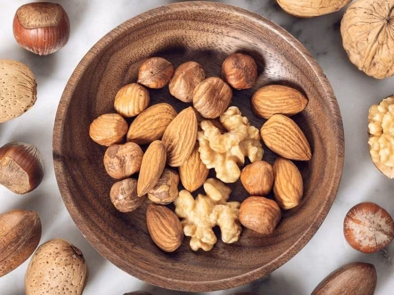 Hạnh nhân, óc chó, hạt điều… cung cấp axit béo không bão hòa và chất xơ, hỗ trợ giảm cholesterol xấu LDL. Mỗi ngày, ăn khoảng 50–60 gram quả hạch là vừa đủ. Có thể dùng trực tiếp hoặc trộn cùng salad, ngũ cốc để tăng hiệu quả. Ảnh minh họa