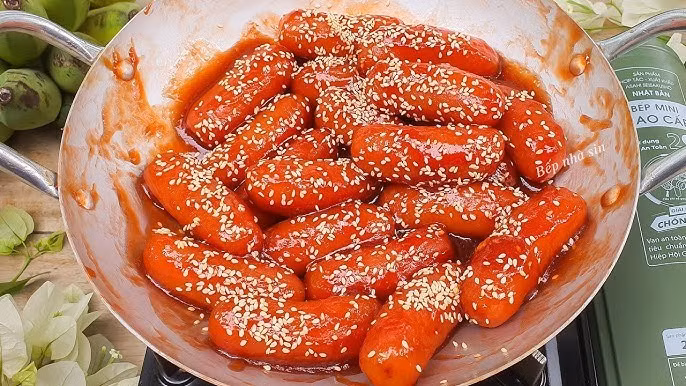 Không ít người khi lần đầu thấy những thanh chuối vàng nâu, tròn đều, óng ánh lớp đường thắng đã ngỡ đó là xúc xích nướng. Ảnh minh hoạ