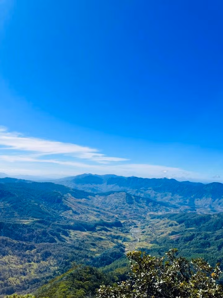 Hành trình khám phá Ngok Kal thường bắt đầu từ thôn Lê Văng một ngôi làng nhỏ bình yên nằm nép mình dưới chân núi. Buổi sớm nơi đây phủ một lớp sương mỏng, những mái nhà sàn thấp thoáng sau tán cây, nhịp sống diễn ra chậm rãi và mộc mạc. Đây cũng là nơi du khách có thể cảm nhận rõ nét văn hóa bản địa trước khi chính thức bước vào cung đường trekking đầy thử thách.