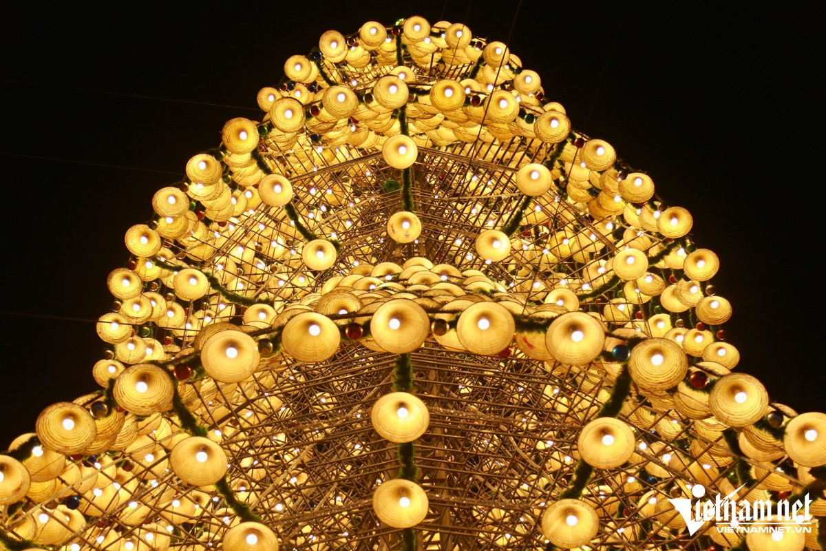 Cây thông nón lá trở thành điểm check-in quen thuộc, thu hút mọi lứa tuổi. Giới trẻ thích thú chụp những bức ảnh “sống ảo”, trong khi các gia đình có trẻ nhỏ và người lớn tuổi cũng tìm đến dạo chơi, hòa mình vào không khí Giáng sinh sớm. Những buổi tối, khuôn viên nhà thờ nhộn nhịp, tiếng cười nói rộn ràng, tạo nên không gian lễ hội ấm áp, thân thiện. Ảnh Báo Vietnamnet