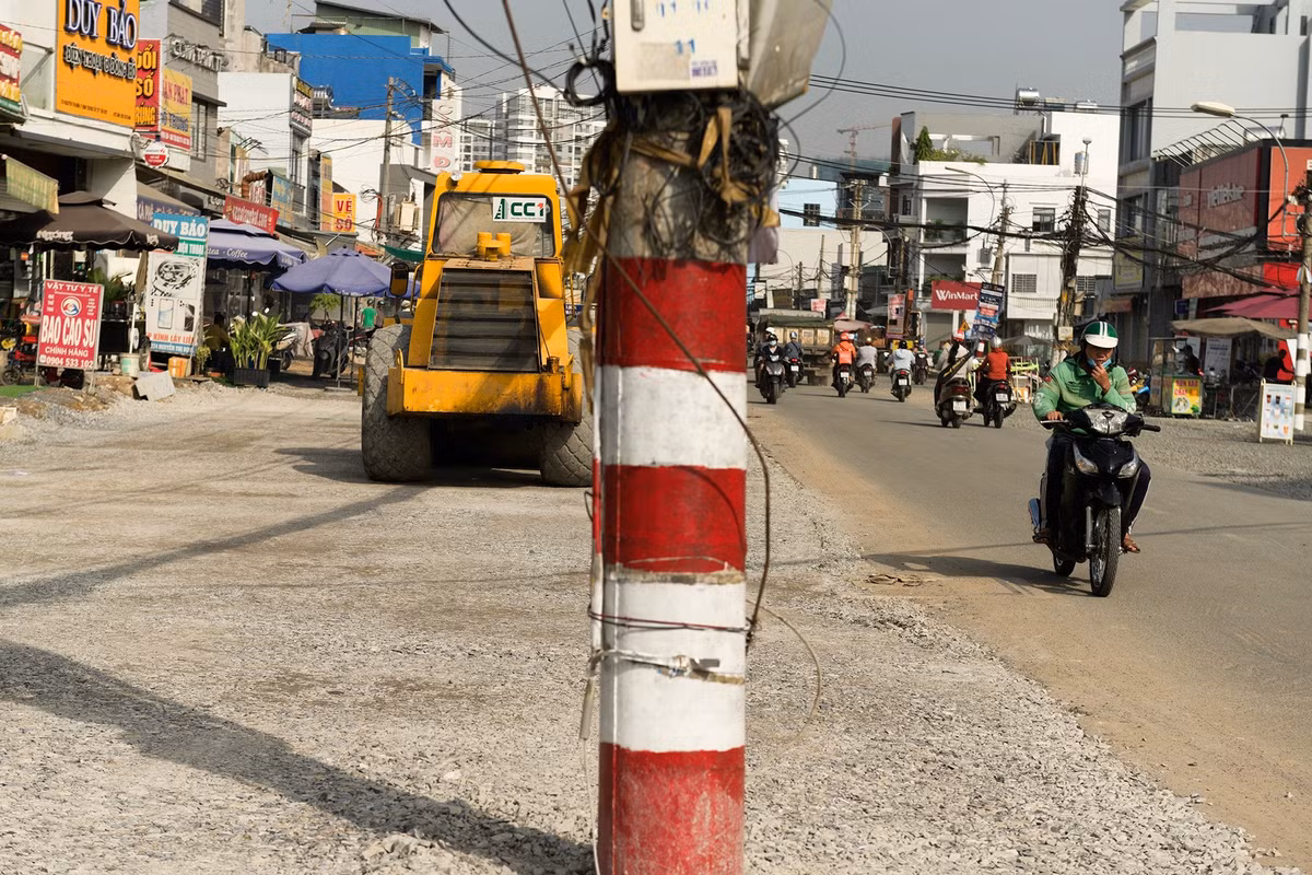 Trong lúc này, dọc tuyến đường Nguyễn Thị Định, nhiều cột điện cùng hệ thống cáp điện - viễn thông vẫn án ngữ giữa lòng đường, tiềm ẩn nguy cơ mất an toàn giao thông khi các hạng mục mở rộng đã được triển khai.