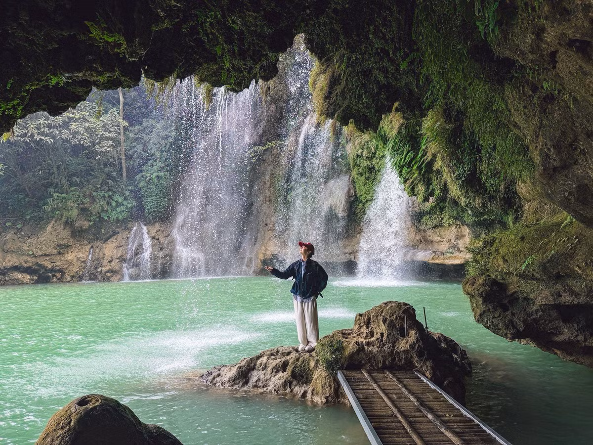 Vào mùa hoa nở, khi thời tiết khô ráo, nước suối trong và ít phù sa, toàn bộ thác hiện lên với gam xanh mát mắt, phản chiếu ánh nắng len qua tán cây. Không gian xung quanh gần như tách biệt với nhịp sống ồn ào, chỉ còn tiếng nước đổ, tiếng gió rừng và mùi ẩm mát đặc trưng của núi rừng Tây Bắc. Ảnh Lăng Văn Toán